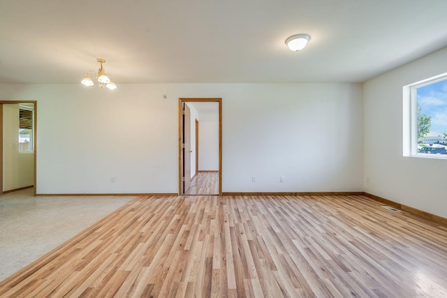 144 Beargrass Ln, Kalispell, MT 59901 - empty room featuring light wood-type flooring, a chandelier, and baseboards