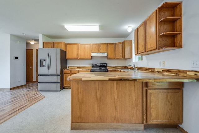 144 Beargrass Ln, Kalispell, MT 59901 - kitchen featuring stainless steel refrigerator with ice dispenser, black range with gas cooktop, under cabinet range hood, a sink, and a peninsula
