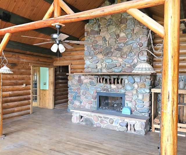 438 Little Mill Creek Rd, Saint Regis, MT 59866 - unfurnished living room featuring log walls, a ceiling fan, wood ceiling, wood finished floors, and a stone fireplace