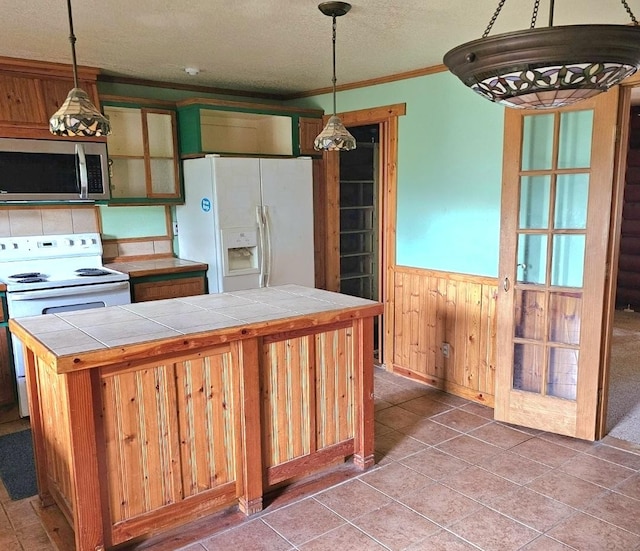438 Little Mill Creek Rd, Saint Regis, MT 59866 - kitchen with white appliances, tile countertops, a wainscoted wall, a textured ceiling, and hanging light fixtures