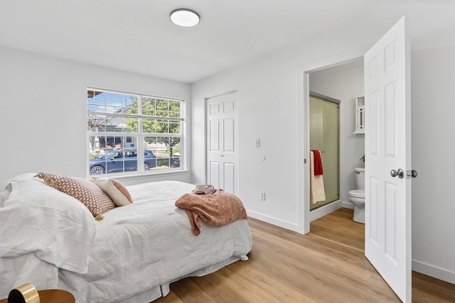 1337A Lily Ct, Missoula, MT 59802 - bedroom featuring light wood-style floors, baseboards, a closet, and connected bathroom