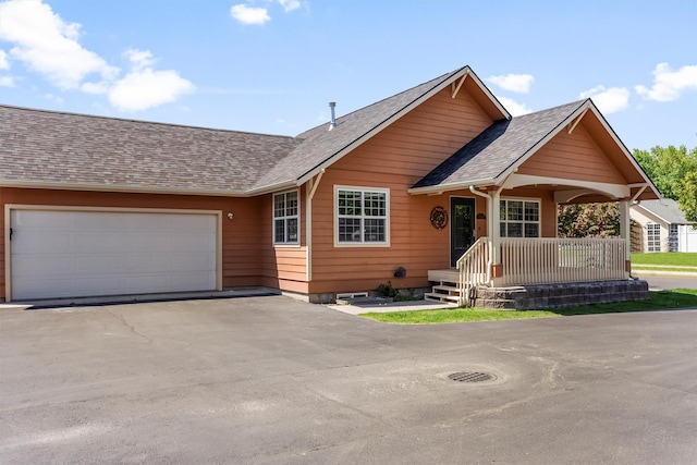 1337A Lily Ct, Missoula, MT 59802 - view of front of house with an attached garage, driveway, a shingled roof, and a porch