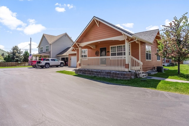 1337A Lily Ct, Missoula, MT 59802 - view of front of home featuring a porch, a shingled roof, central AC unit, and a front yard