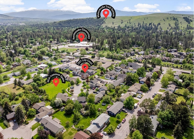 1337A Lily Ct, Missoula, MT 59802 - aerial view of property and surrounding area featuring a mountain backdrop, nearby suburban area, and a heavily wooded area