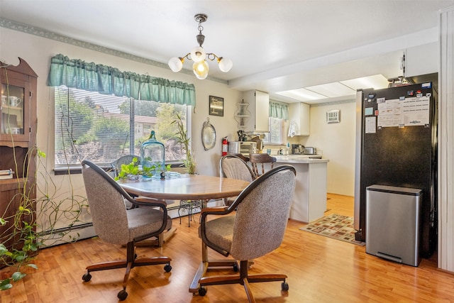2404 56th St, Missoula, MT 59803 - dining room with baseboard heating, light wood finished floors, and a chandelier