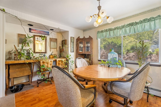 2404 56th St, Missoula, MT 59803 - dining area featuring a chandelier, wood finished floors, and a baseboard radiator