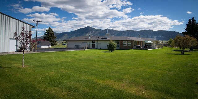 345 Ash Dr, Butte, MT 59701 - view of grassy yard with a garage, an outbuilding, and a mountain view