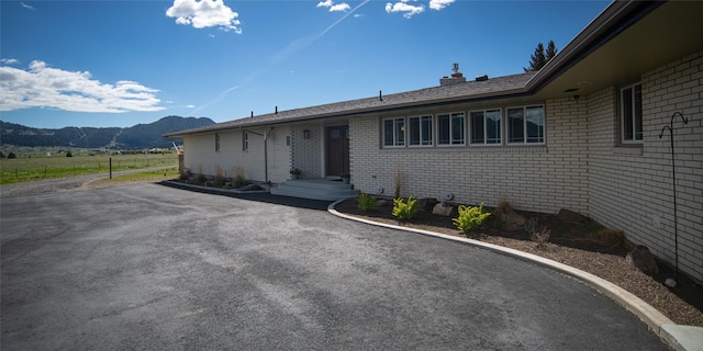 345 Ash Dr, Butte, MT 59701 - view of front of property with a mountain view, a chimney, and brick siding
