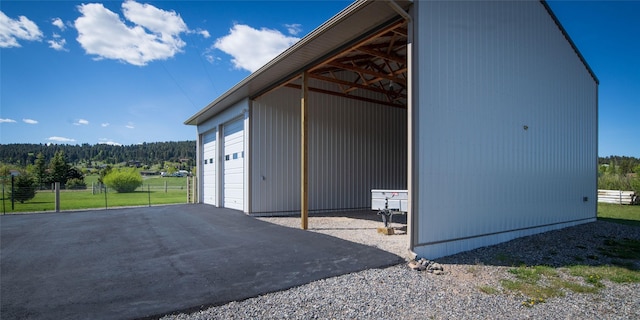 345 Ash Dr, Butte, MT 59701 - view of side of home featuring an outdoor structure, a detached garage, and a view of trees