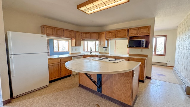 6180 Elkhorn Rd, Helena, MT 59602 - kitchen featuring white appliances, light countertops, a baseboard heating unit, a kitchen island, and a sink