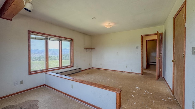 6180 Elkhorn Rd, Helena, MT 59602 - spare room featuring baseboard heating, baseboards, a mountain view, and a baseboard heating unit