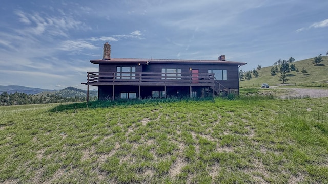 6180 Elkhorn Rd, Helena, MT 59602 - back of house with a chimney and a deck with mountain view