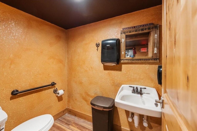 300 Morning View Dr, Kalispell, MT 59901 - half bathroom featuring toilet, wood finished floors, a sink, and baseboards