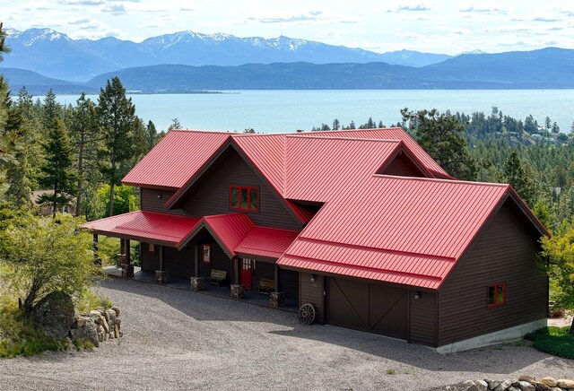 251 S Eighty Dr, Somers, MT 59932 - rustic home with a porch, metal roof, a garage, and a water and mountain view