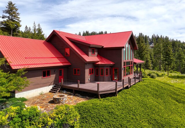 251 S Eighty Dr, Somers, MT 59932 - view of front of home with an outdoor fire pit, a wooden deck, and a metal roof