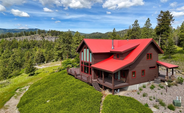 251 S Eighty Dr, Somers, MT 59932 - rear view of property featuring a view of trees, a deck with mountain view, and a metal roof
