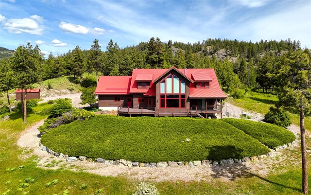 251 S Eighty Dr, Somers, MT 59932 - rear view of property with a view of trees, a wooden deck, metal roof, and dirt driveway