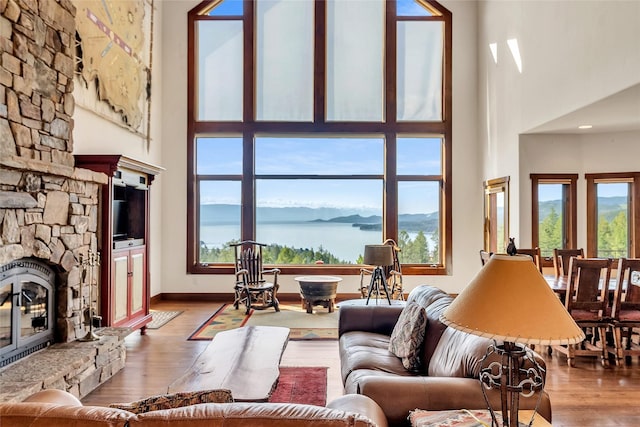 251 S Eighty Dr, Somers, MT 59932 - living room featuring a towering ceiling, a stone fireplace, plenty of natural light, and wood finished floors