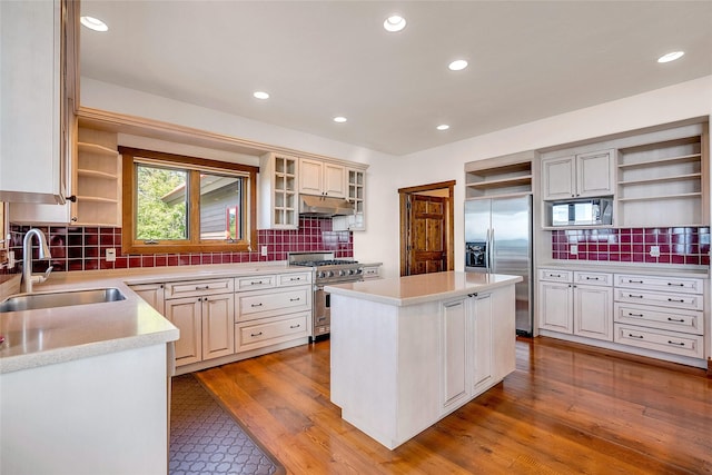 251 S Eighty Dr, Somers, MT 59932 - kitchen with open shelves, appliances with stainless steel finishes, a sink, under cabinet range hood, and decorative backsplash