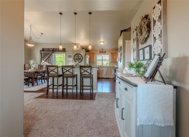 5946 Johnson Rd, East Helena, MT 59635 - kitchen with a kitchen island, a breakfast bar, dark carpet, freestanding refrigerator, and hanging light fixtures