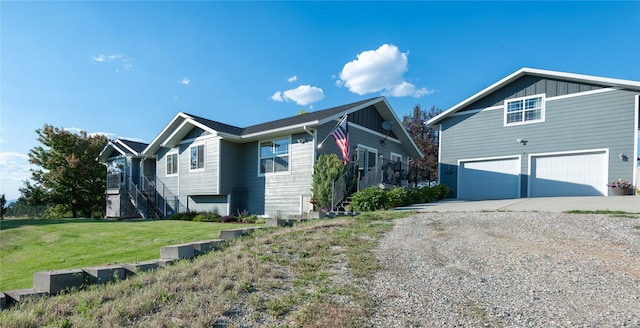 5946 Johnson Rd, East Helena, MT 59635 - view of side of property featuring gravel driveway, an attached garage, board and batten siding, and a yard