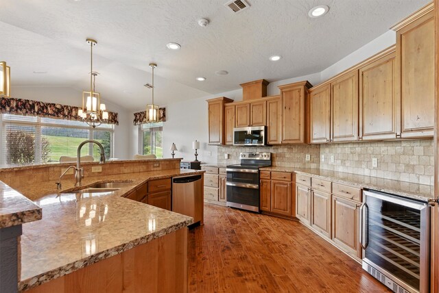 1112 Anglers Bend Way, Missoula, MT 59802 - kitchen with stainless steel appliances, wine cooler, a sink, wood finished floors, and decorative backsplash