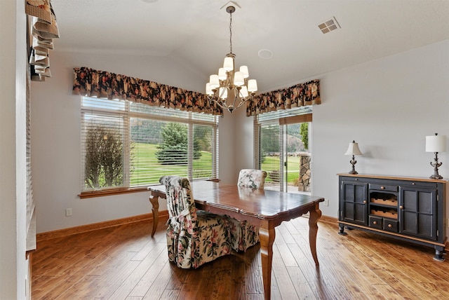1112 Anglers Bend Way, Missoula, MT 59802 - dining area featuring a chandelier, vaulted ceiling, wood-type flooring, and baseboards