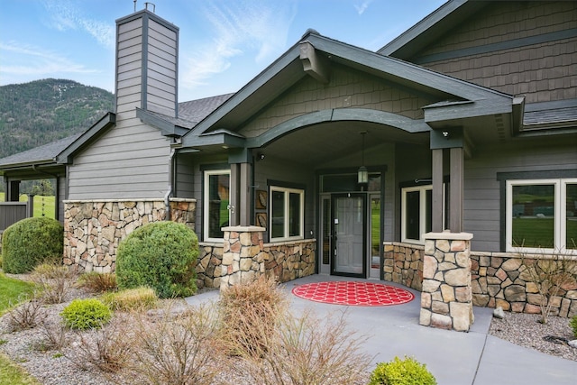 1112 Anglers Bend Way, Missoula, MT 59802 - property entrance featuring stone siding, a chimney, and a mountain view