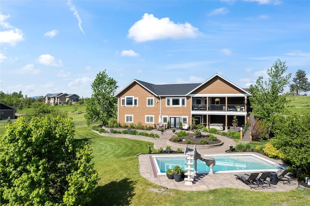 1683 Foxtail Dr, Kalispell, MT 59901 - back of property with stairs, a lawn, a patio, an outdoor pool, and a balcony