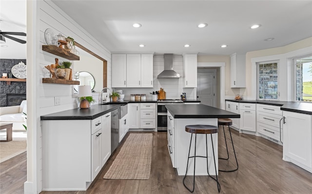 1683 Foxtail Dr, Kalispell, MT 59901 - kitchen with wall chimney range hood, appliances with stainless steel finishes, dark countertops, and recessed lighting