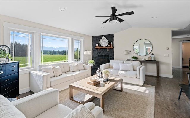 1683 Foxtail Dr, Kalispell, MT 59901 - living room with dark wood finished floors, vaulted ceiling, a ceiling fan, and a stone fireplace