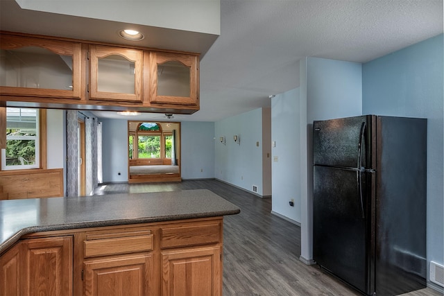 33958 Connolly Way, Polson, MT 59860 - kitchen with freestanding refrigerator, wood finished floors, open floor plan, glass insert cabinets, and brown cabinetry