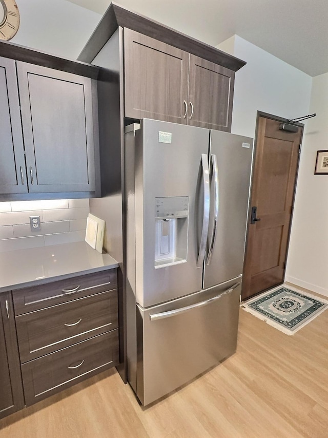 100 Woodlands Way Unit W-204, Kalispell, MT 59901 - kitchen with stainless steel fridge, light wood-type flooring, backsplash, and dark brown cabinets