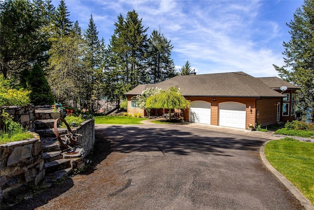 29137 Rocky Point Rd, Polson, MT 59860 - view of front facade featuring asphalt driveway, a garage, and roof with shingles