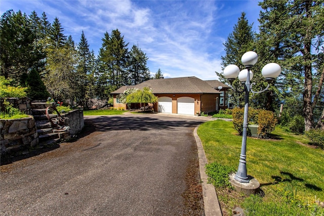 29137 Rocky Point Rd, Polson, MT 59860 - view of front facade with a garage, asphalt driveway, and a front lawn