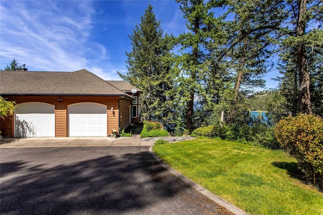 29137 Rocky Point Rd, Polson, MT 59860 - view of front of house with a front lawn, a shingled roof, and a garage