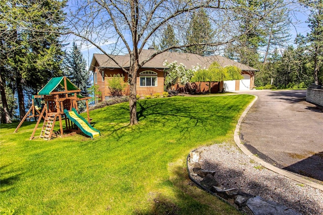 29137 Rocky Point Rd, Polson, MT 59860 - view of front facade with a playground, a front lawn, and roof with shingles