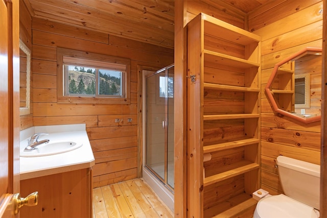 15530 S Sperry Grade Rd, Greenough, MT 59823 - bathroom featuring toilet, wood walls, vanity, a shower stall, and hardwood / wood-style flooring