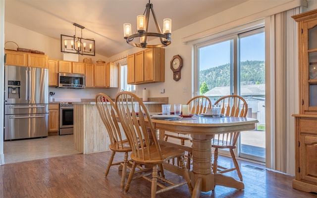 2216 Ruddy Duck Dr, Kalispell, MT 59901 - dining space with a chandelier, wood finished floors, and lofted ceiling