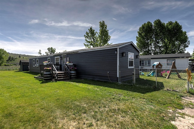 13414 Ashlyn Dr, Missoula, MT 59808 - rear view of house featuring a wooden deck and a playground
