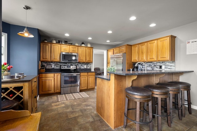 25 Logan Way, Kalispell, MT 59901 - kitchen with appliances with stainless steel finishes, dark countertops, recessed lighting, a peninsula, and tasteful backsplash