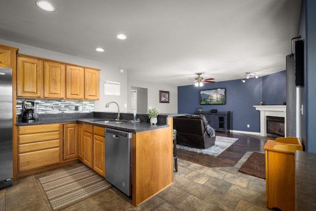 25 Logan Way, Kalispell, MT 59901 - kitchen with stainless steel appliances, open floor plan, ceiling fan, recessed lighting, and a glass covered fireplace