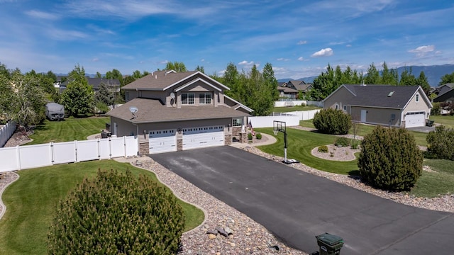25 Logan Way, Kalispell, MT 59901 - traditional-style home with asphalt driveway, stone siding, a residential view, a gate, and an attached garage