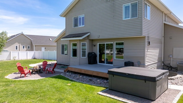 25 Logan Way, Kalispell, MT 59901 - back of property with a hot tub, a fire pit, and a wooden deck