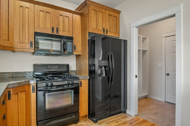 2211 S Russell St Unit B, Missoula, MT 59801 - kitchen with black appliances, tile counters, and brown cabinets