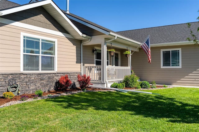 140 Ali Loop, Kalispell, MT 59901 - property entrance featuring a lawn, covered porch, stone siding, and a shingled roof