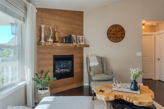 140 Ali Loop, Kalispell, MT 59901 - living area featuring healthy amount of natural light, wood finished floors, a glass covered fireplace, and wood walls