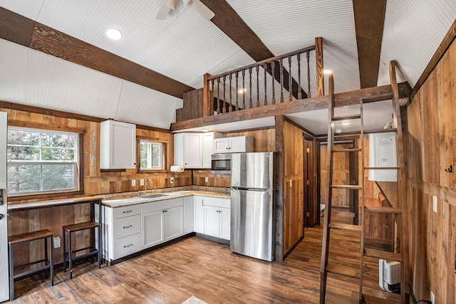 77 Rumsey Rd, Philipsburg, MT 59858 - kitchen featuring appliances with stainless steel finishes, a sink, wood walls, dark wood-type flooring, and white cabinetry