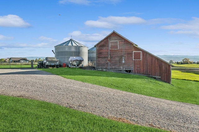 515 Manning Rd, Kalispell, MT 59901 - view of side of property featuring a barn, gravel driveway, a lawn, and an outbuilding