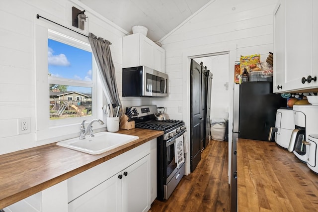515 Manning Rd, Kalispell, MT 59901 - kitchen with stainless steel appliances, butcher block countertops, a sink, vaulted ceiling, and white cabinets